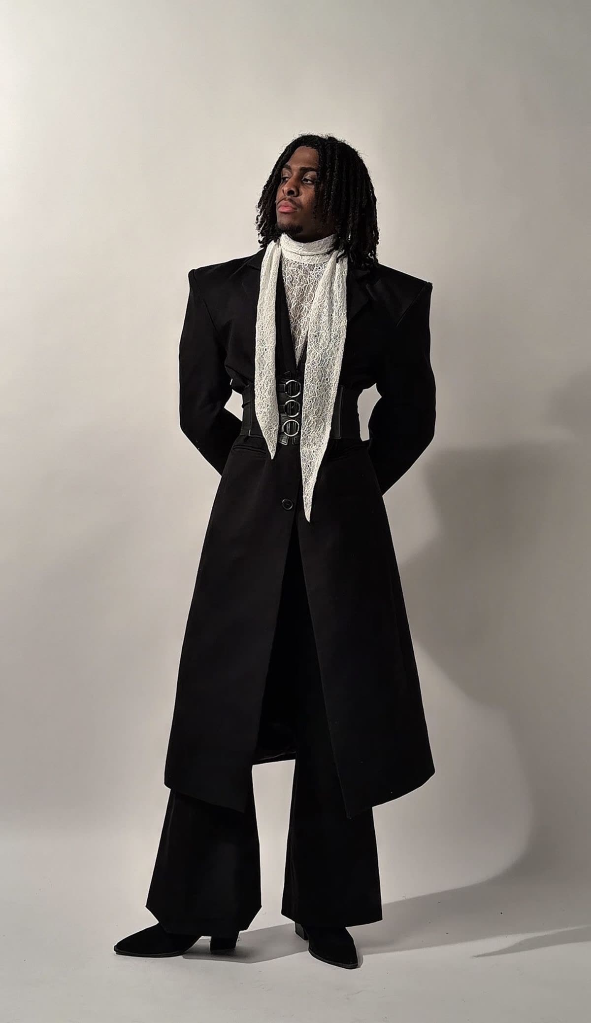 Menswear look, a long black tailored coat with a soft cravat