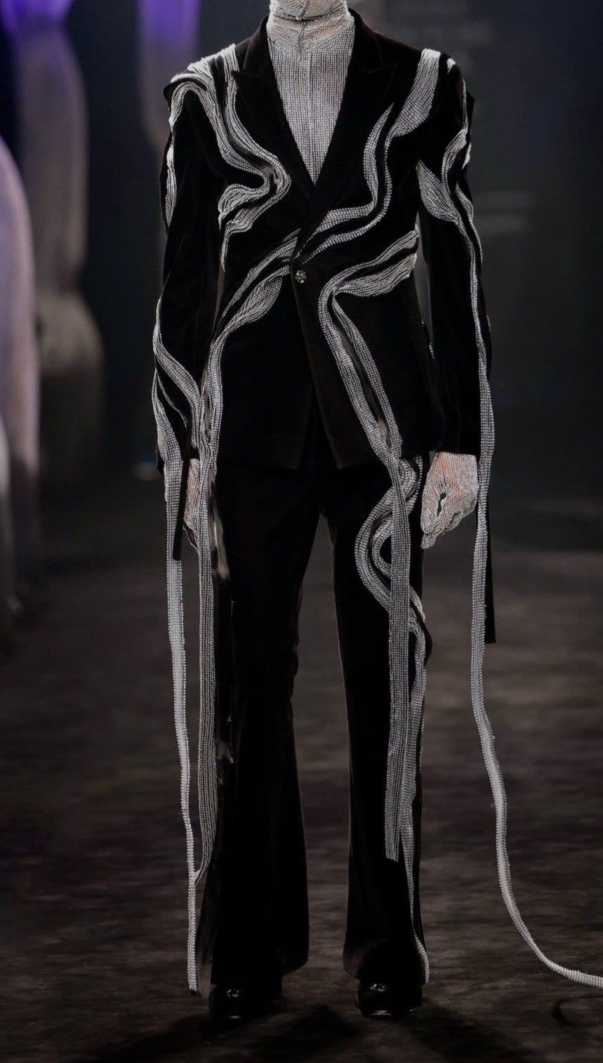 Menswear look, a black suit with sculptural white ribbon detailing
